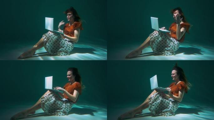 年轻迷人的快乐自由职业者商业女性使用笔记本电脑网络摄像头视频通话水下慢动作与合作伙伴交谈