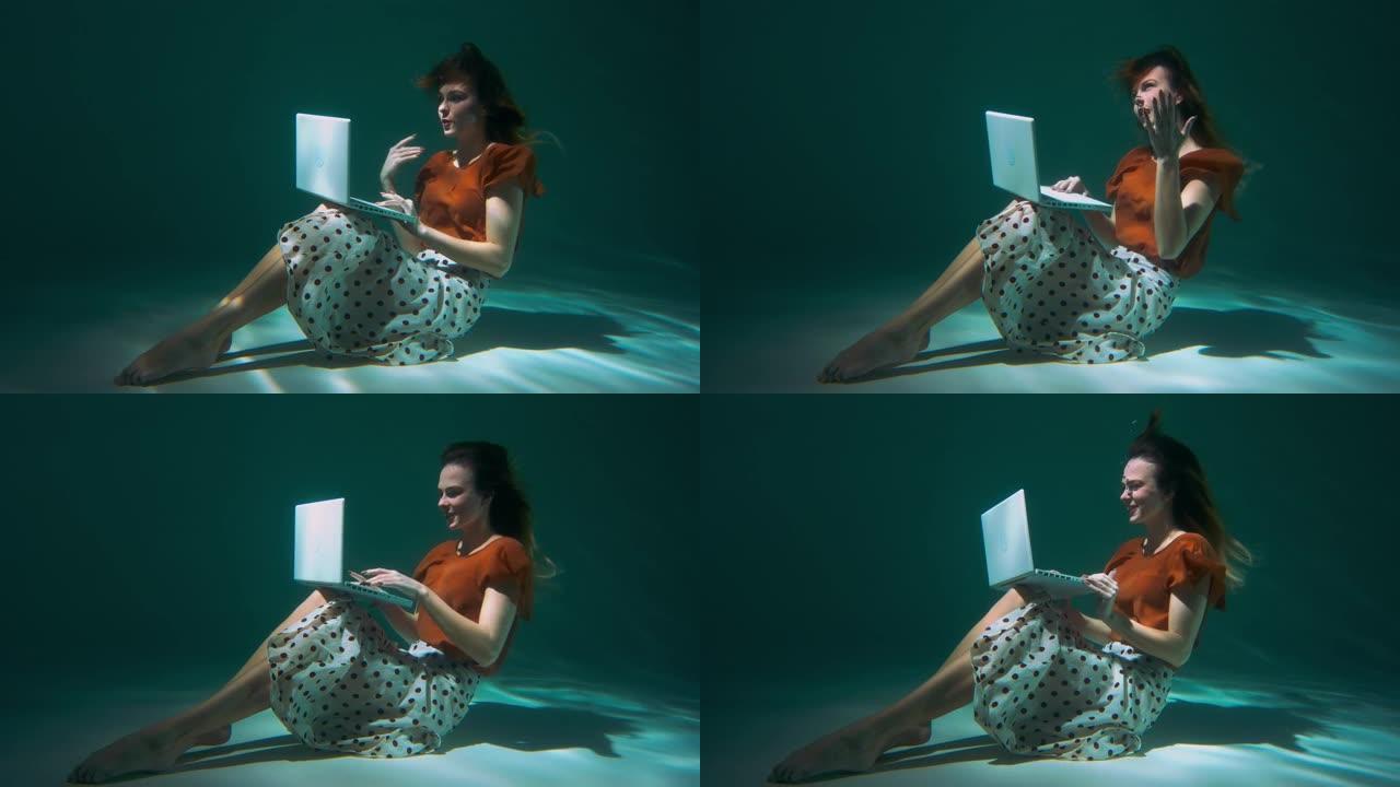 年轻迷人的快乐自由职业者商业女性使用笔记本电脑网络摄像头视频通话水下慢动作与合作伙伴交谈
