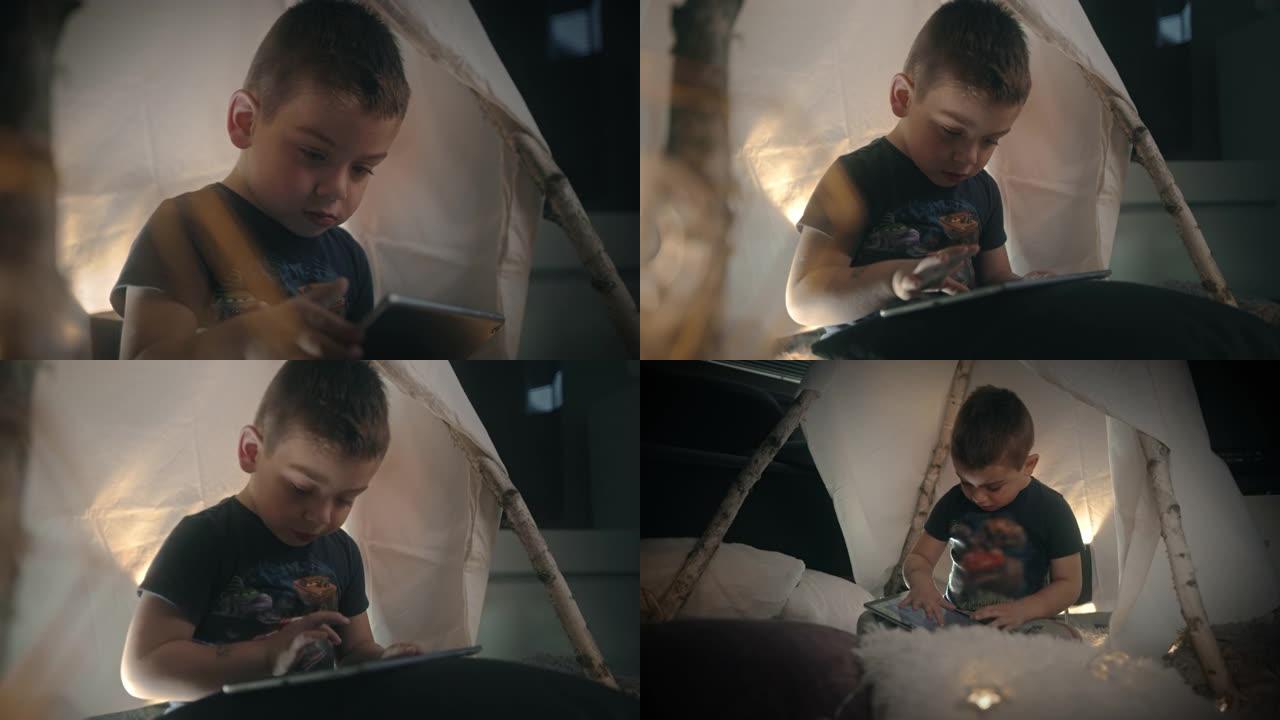 小男孩在帐篷里使用数字平板电脑