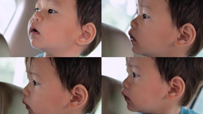15个月大的小男孩的特写亚洲种族，看着一些东西享受窗外的空闲时间。儿童生活中的一天。