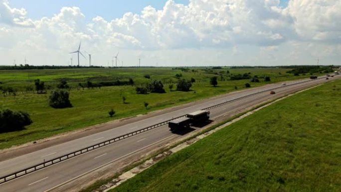 高速公路在美丽的农田和风力涡轮机的背景