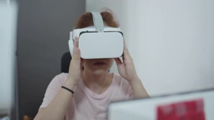 女性使用VR耳机，在虚拟现实世界中玩耍，在家庭办公室