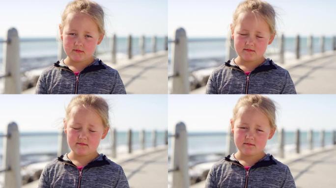 在澳大利亚度假时，海滩上小女孩的抑郁、悲伤和脸对精神障碍感到不满。沮丧的小孩童年时的悲伤对在海滨长廊
