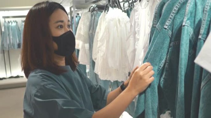 新常态: 亚洲女人戴着口罩购物