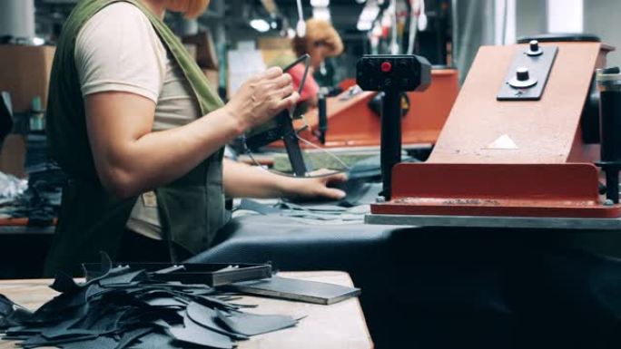 鞋类工厂的工人正在削减靴子的图案
