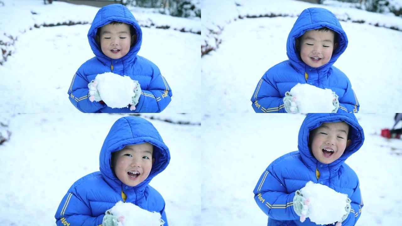 蹒跚学步的小男孩在冬天玩雪