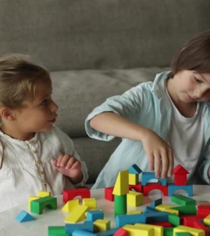 Two focused cute sibling kids playing building blo