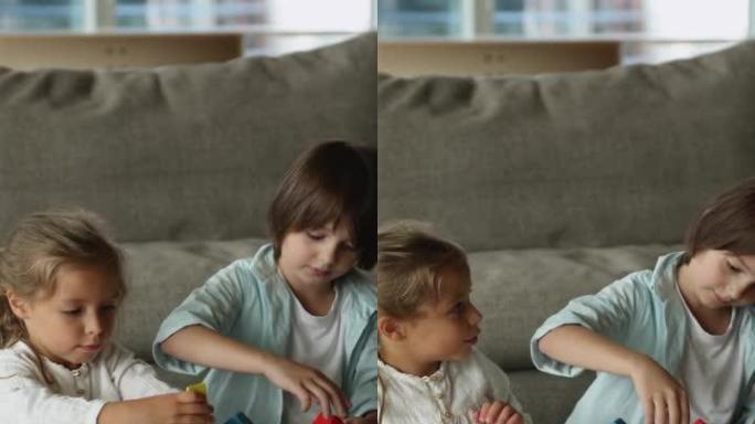 Two focused cute sibling kids playing building blo