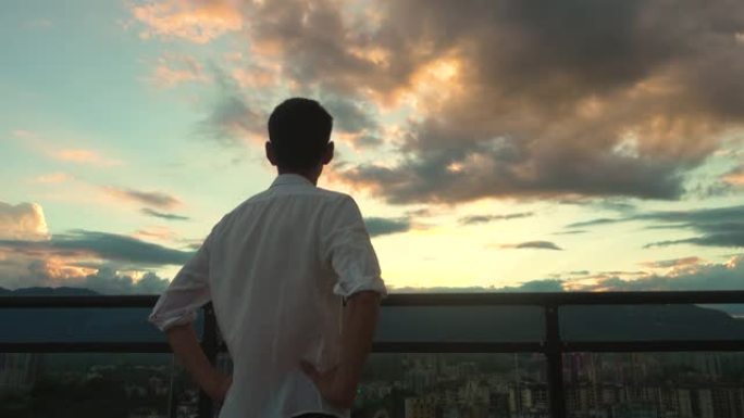 年轻人在屋顶上观看城市日落