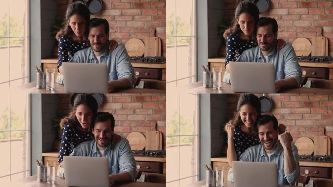 快乐的夫妇检查电子邮件使用笔记本电脑庆祝收到的好消息