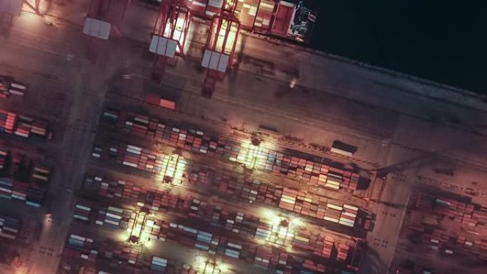 带集装箱船的繁忙工业港口的T/L俯视图，黄昏到夜晚的过渡