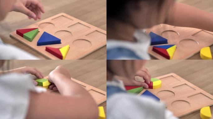 6-7岁的亚洲女孩在家里玩彩色木制玩具积木的后视图。家庭教育和远程学习