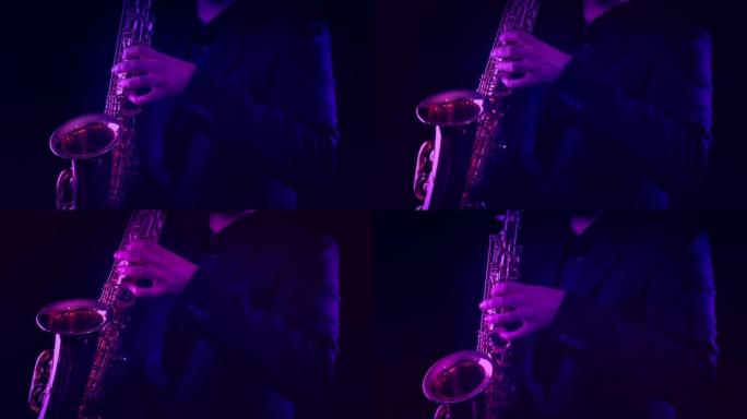 男子在五颜六色的灯光下在舞台上演奏萨克斯管