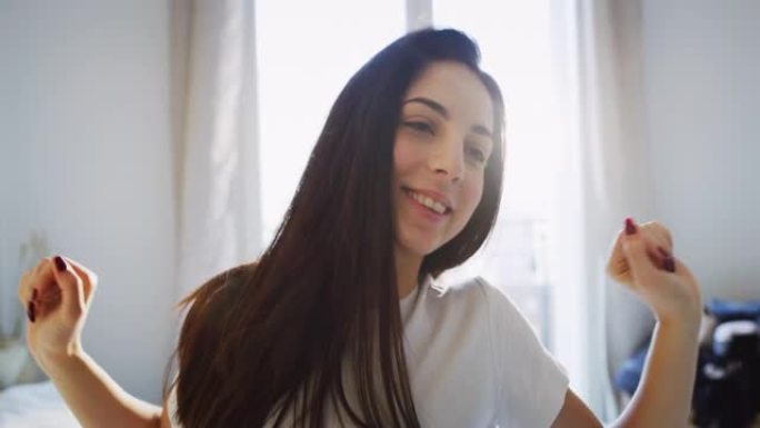 真实的近距离拍摄的一个年轻的黑发女子是醒来的床