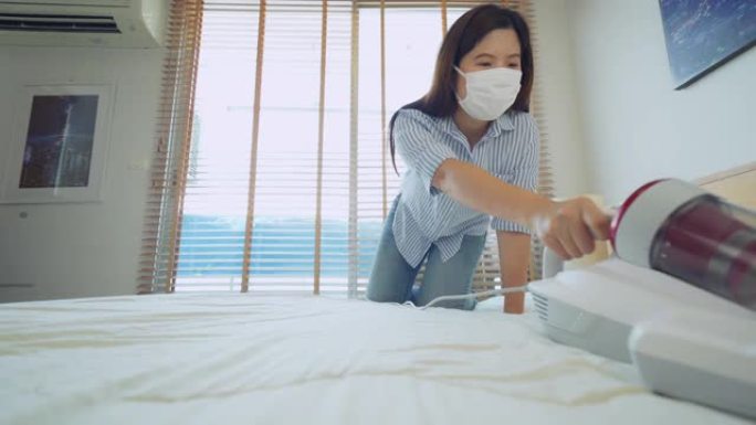在床上使用真空吸尘器的女人