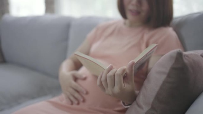 怀孕的亚洲妇女看书休息时间与婴儿