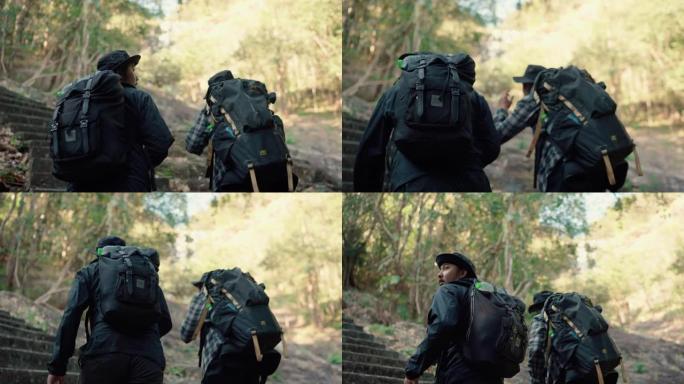 两个旅行者背着背包和朋友在瀑布附近的森林里旅行。