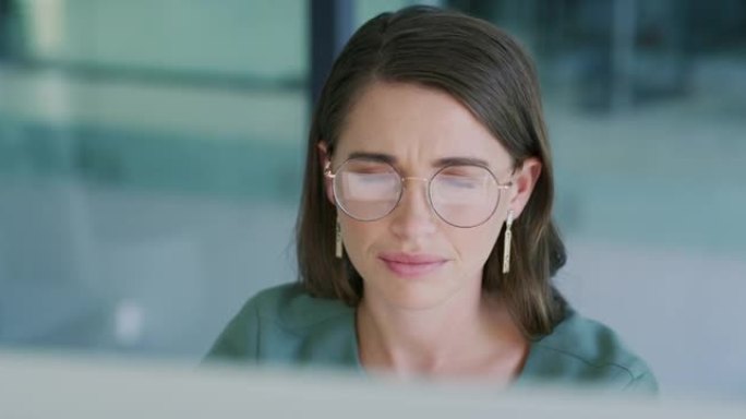 4k视频片段，一位年轻的女商人在现代办公室中使用计算机时皱着眉头