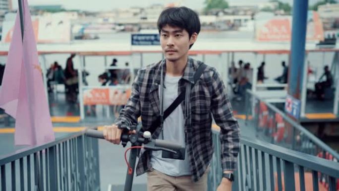 一个年轻的亚洲男子乘电动滑板车旅行