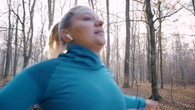 戴着入耳式耳机的SLO MO女人在为慢跑热身时做伸展运动