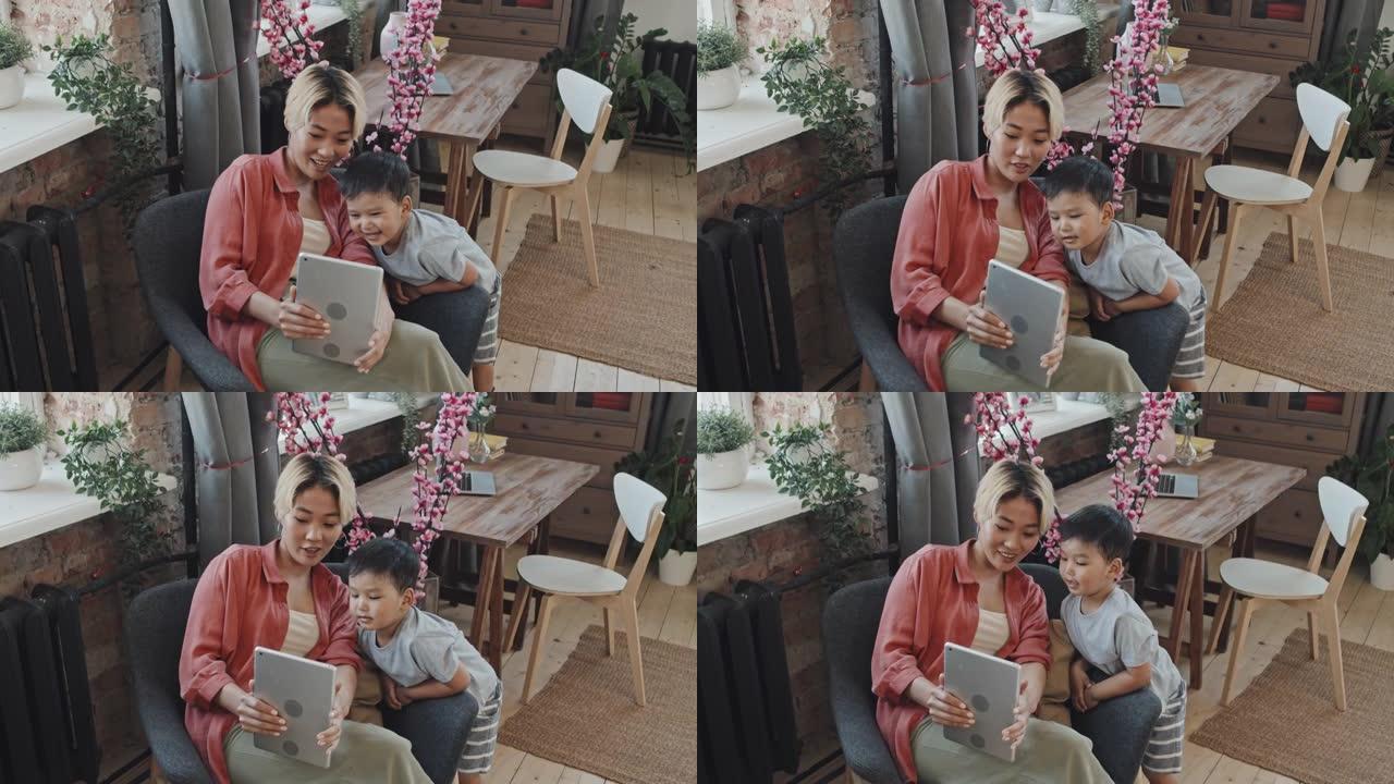 亚洲妈妈和小儿子看着数字平板电脑