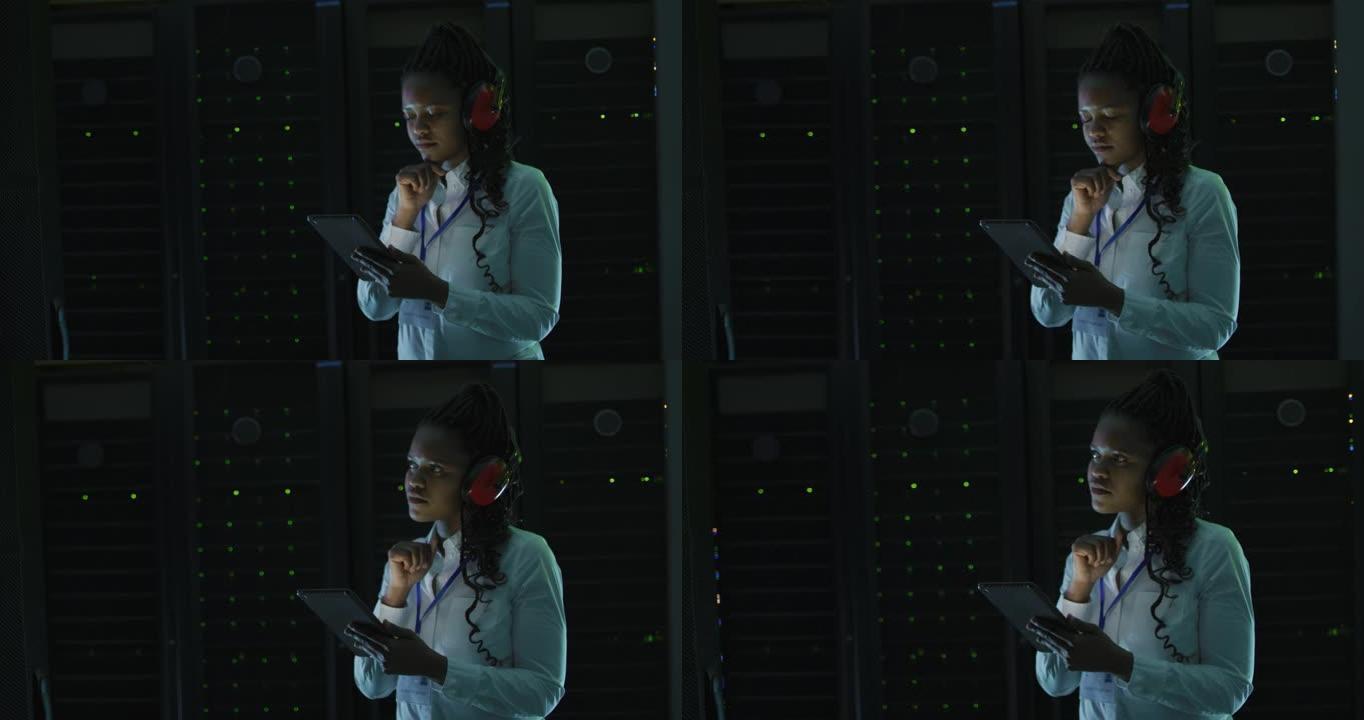 非裔美国女计算机技术员使用平板电脑在商务服务器机房工作