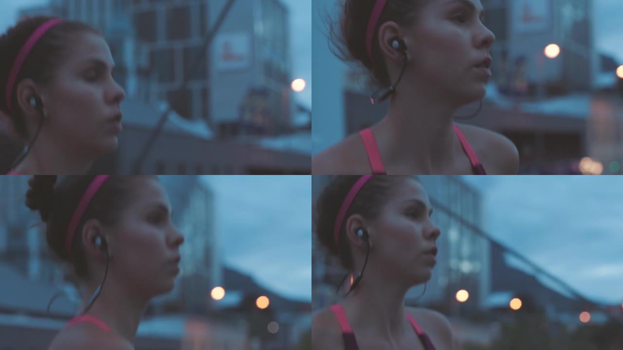 适合晚上在城市里跑步和慢跑的女人。一个认真的年轻运动员在有氧运动和耐力训练时听音乐的特写镜头。为了更