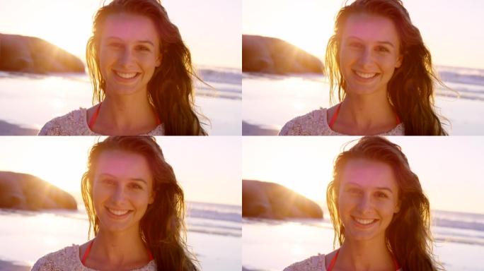 4k视频片段，一位迷人的年轻女子在日落时独自站在海滩上