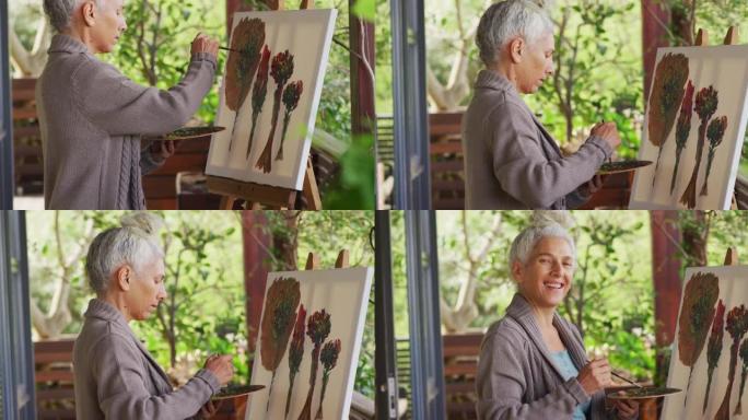 高级混血女人的肖像在阳台上绘画和微笑
