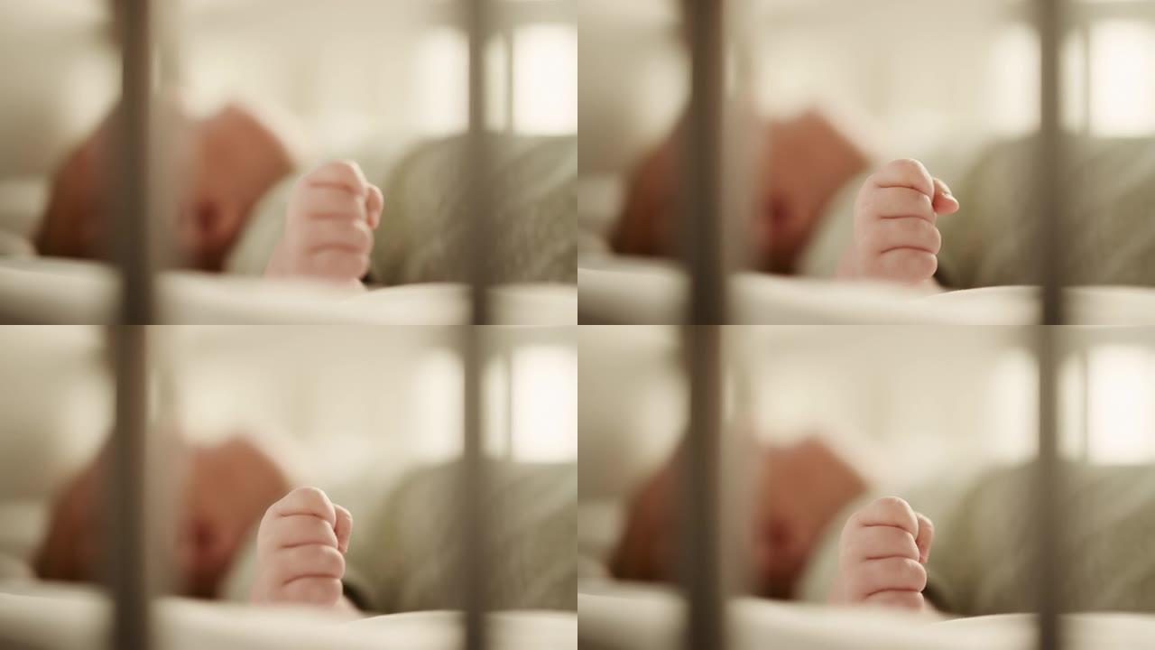真实的特写镜头，一个可爱的新生婴儿躺在婴儿床的背上。高加索新生儿蹒跚学步的微小人手是焦点。童年、新生