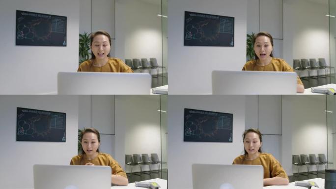 年轻女子在办公室用笔记本电脑进行视频通话