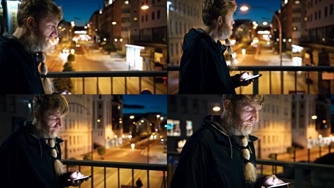 晚上在城市的人行道上行走时，留着长胡须的男子使用智能手机