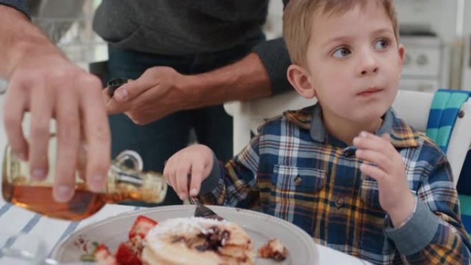 父亲为儿子准备早餐华夫饼可爱的小男孩在家厨房享受美味的自制饭菜4k