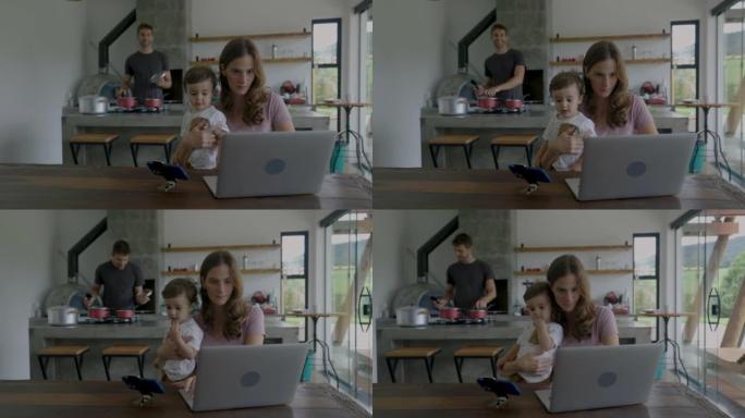 巴西母亲在家工作，用手机上的视频分散儿子的注意力，而父亲则在后台准备午餐