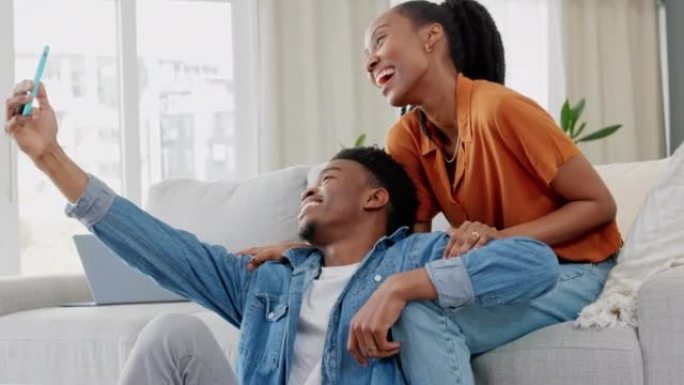 幸福的黑人夫妇，自拍视频和手机微笑在客厅的沙发上，在幸福的家中放松。恋爱中的非洲男人和女人在智能手机