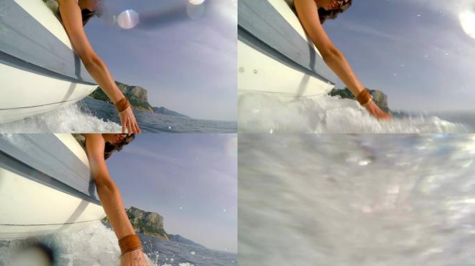 4k视频片段，一位迷人的年轻女子在意大利乘船时玩水