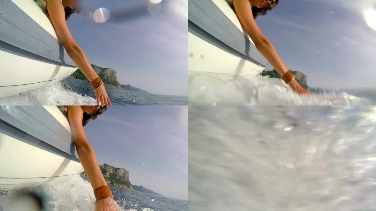 4k视频片段，一位迷人的年轻女子在意大利乘船时玩水