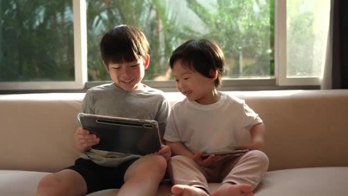 哥哥看着平板电脑，一个哥哥打电话给弟弟看他的平板电脑，表达了兄弟分享的爱