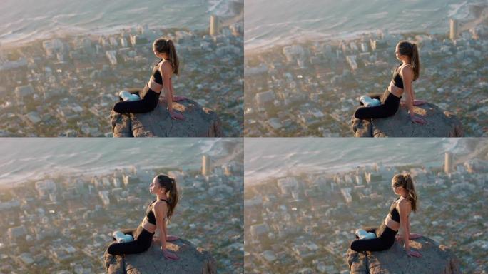 山顶上健康的女人在日落时看着平静的海景女孩坐在悬崖边享受自由沉思之旅