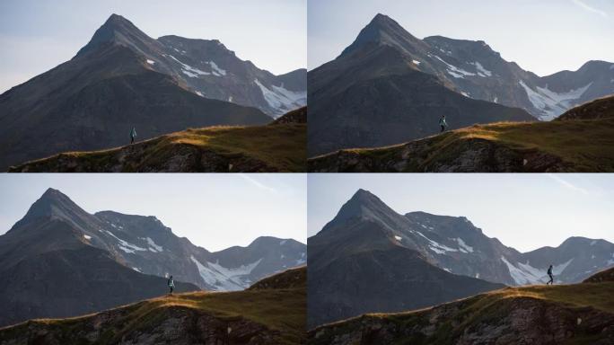 年轻的女徒步旅行者走在被山峰包围的山脊步道上