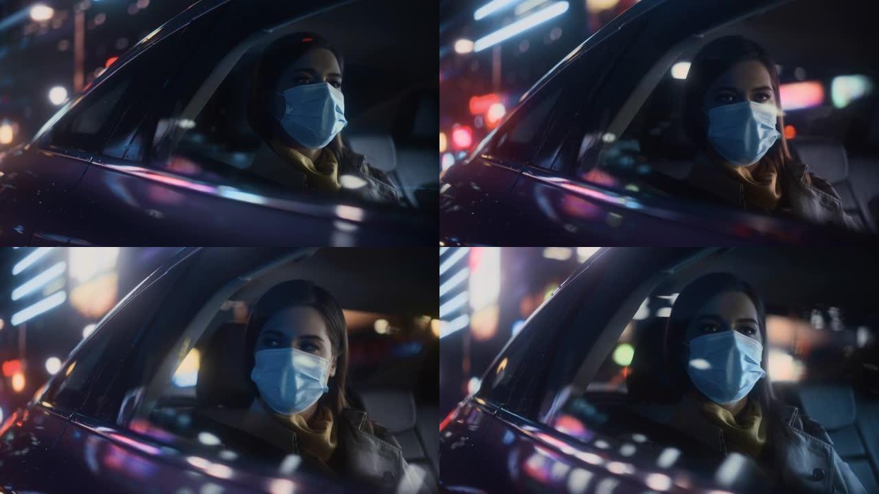 戴着口罩的女性晚上在出租车的后座上通勤回家。美丽的女乘客在城市街道上开着霓虹灯的汽车时看着窗外。