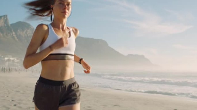 健康，健康和运动的活跃，运动的女性在沙滩上用耳机跑步。适合女性慢跑，一边做有氧运动一边享受新鲜空气，