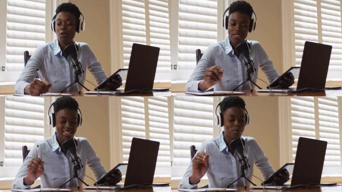 非裔美国妇女戴耳机做笔记在家唱歌