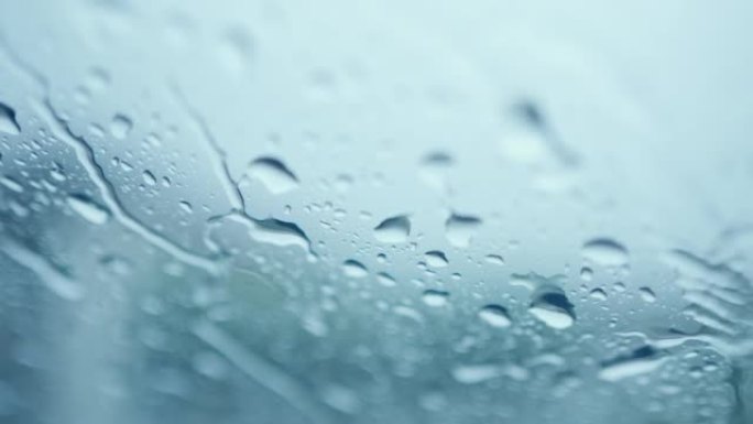 蓝色绿松石背景玻璃上的雨滴