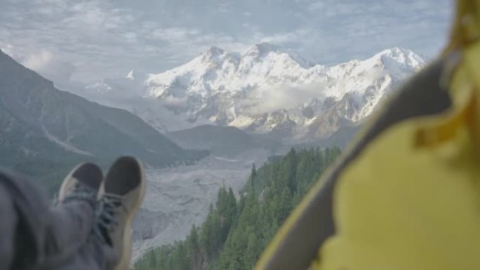 从角度来看，坐在上面的旅行者展示了早晨被雪和冰川覆盖的令人惊叹的自然风光。种族多样化的旅行者概念。与