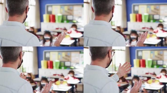 戴着口罩的白人男老师在学校里教学生的后视图
