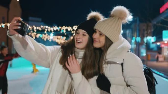 两名年轻女子在溜冰场上使用手机自拍