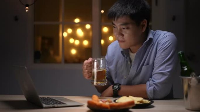 男人在家里的笔记本电脑上与朋友一起喝啤酒