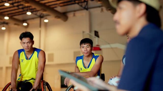 轮椅篮球运动员在球场上与教练会面。