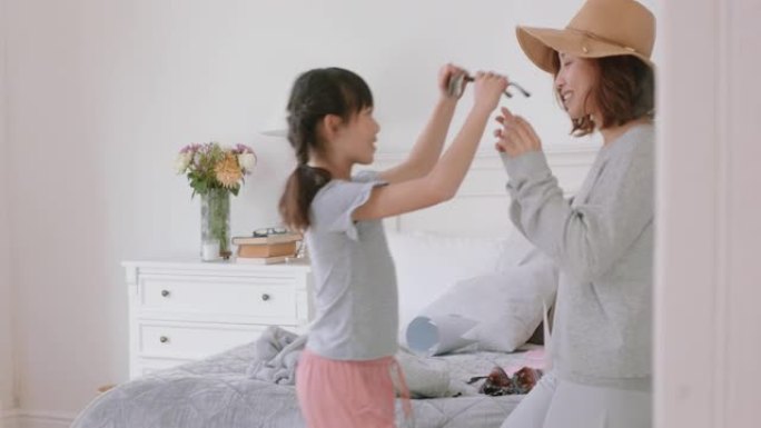 亚洲母女在家里玩装扮游戏小女孩和妈妈玩得开心周末和孩子一起享受顽皮的一天快乐的家庭4k镜头